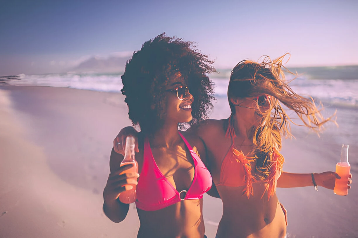 girl walking happily with her friend in bikini